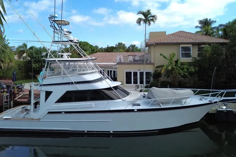 The Image of 1989 Striker 62 yacht docked by a tropical waterfront home. - 0