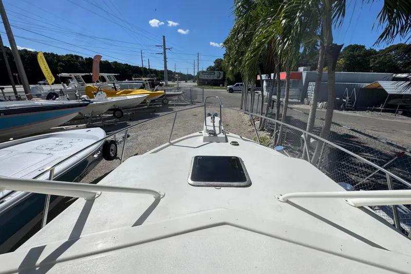 Slide: The Image of 1997 Parker 2510 Walkaround boat on display, surrounded by other boats and palm trees. - 2