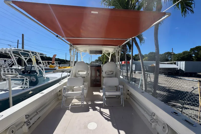 Slide: The Image of 1997 Parker 2510 Walkaround boat interior with seating and canopy, docked outdoors. - 4