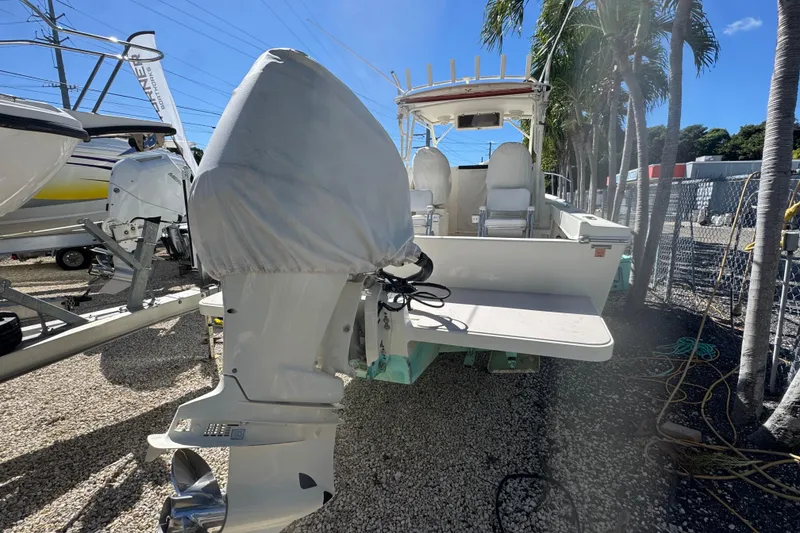 Slide: The Image of 1997 Parker 2510 Walkaround boat with covered outboard motor, parked outdoors. - 7