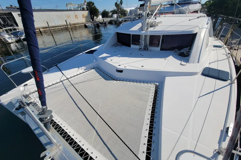 Slide: The Image of 2014 Leopard 39 catamaran docked at a marina, featuring spacious deck and netting. - 12