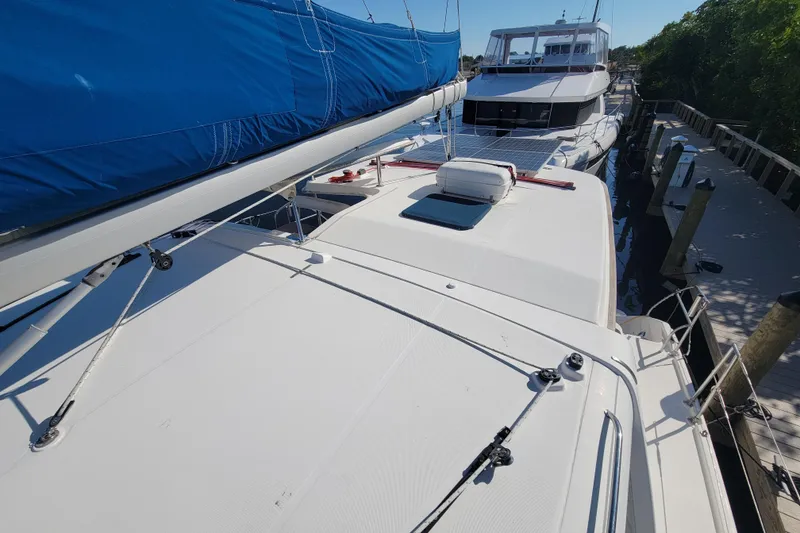 Slide: The Image of 2014 Leopard 39 catamaran with blue sail cover docked beside another boat. - 13