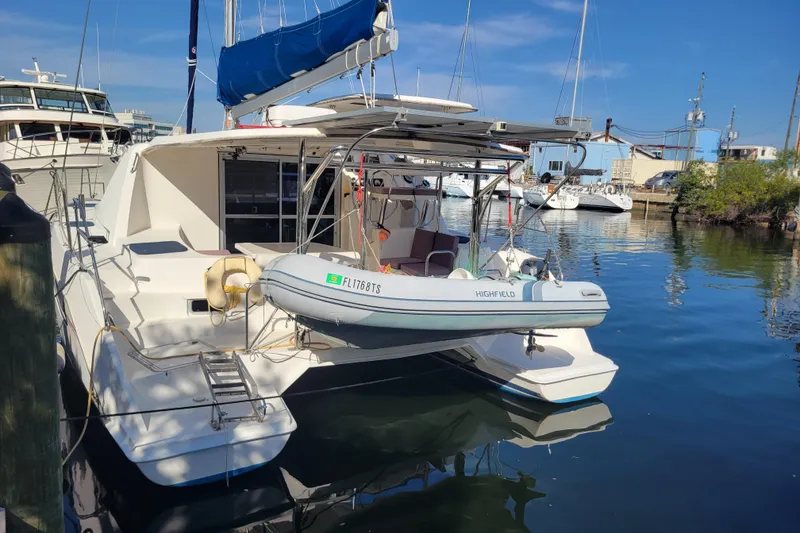 Slide: The Image of 2014 Leopard 39 catamaran docked with dinghy, blue sky background. - 14