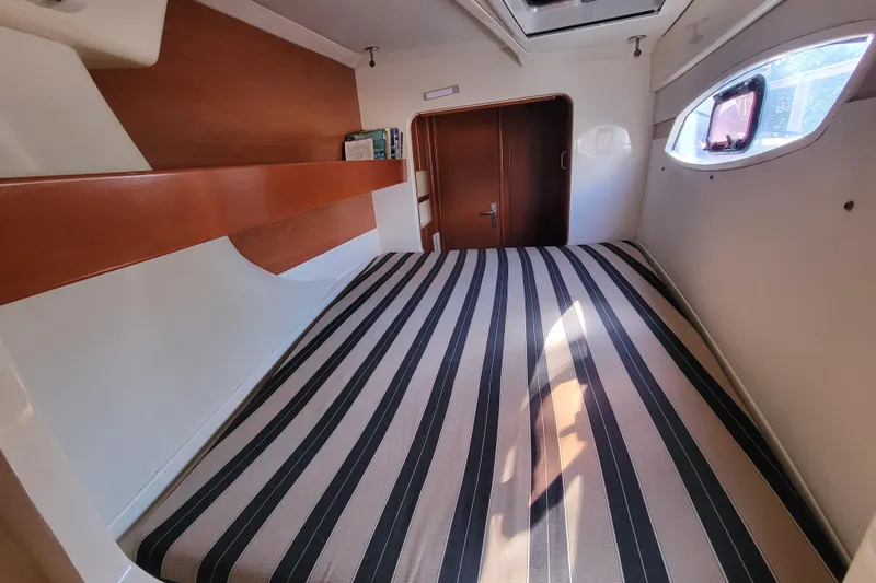 Slide: The Image of Cozy cabin interior of 2014 Leopard 39 yacht with striped bedding and wooden accents. - 3