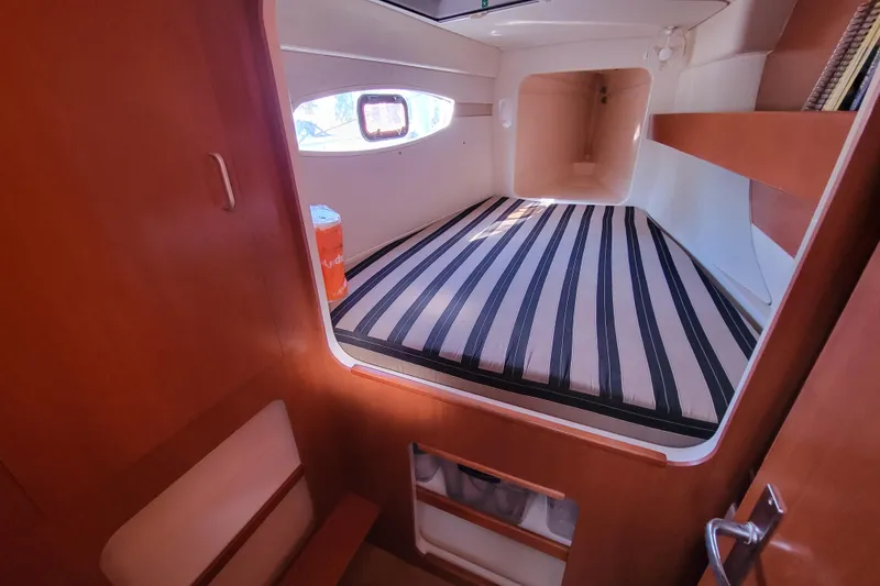 Slide: The Image of Cabin interior of 2014 Leopard 39 yacht with striped bedding and wooden finish. - 8