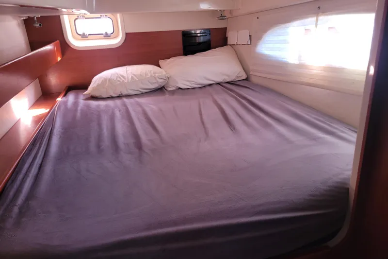 Slide: The Image of Cozy cabin bed in a 2014 Leopard 39 yacht, featuring pillows and natural light. - 9