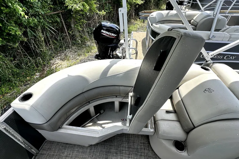 Slide: The Image of 2022 Cypress Cay Seabreeze 232 boat interior with gray seating and Mercury outboard motor. - 12
