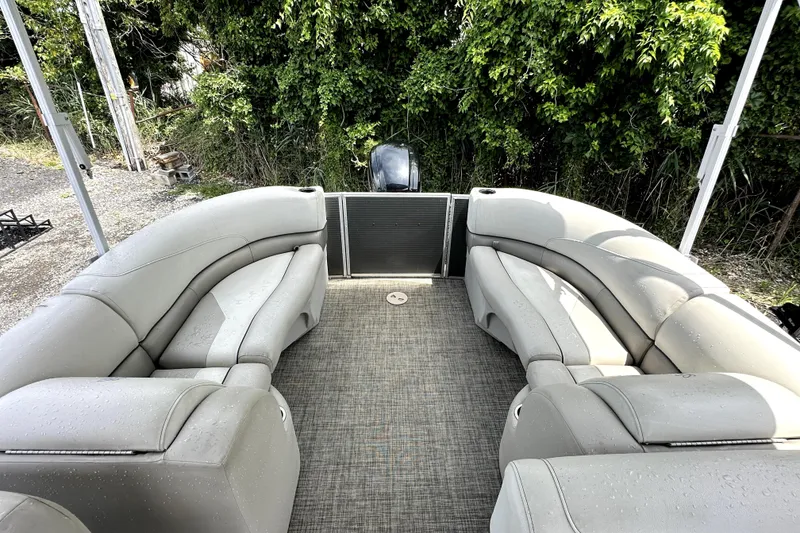 Slide: The Image of 2022 Cypress Cay Seabreeze 232 pontoon boat with spacious seating and lush greenery backdrop. - 4