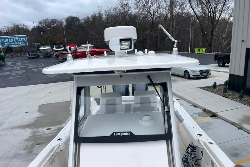 Slide: The Image of 2012 Everglades 295 Center Console boat at dockside, surrounded by trees and parked vehicles. - 29