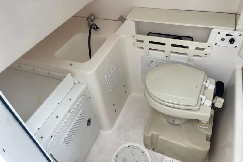 Slide: The Image of 2012 Everglades 295 Center Console boat interior with toilet and sink. - 32