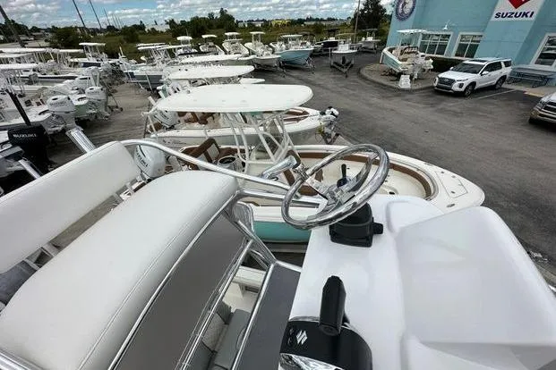 Slide: The Image of 2024 Avenger AV26 boat steering console in a marina with multiple boats. - 10