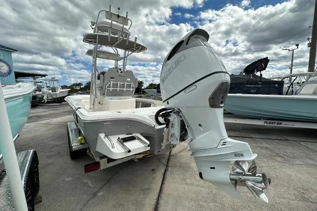 Slide: The Image of 2024 Avenger AV26 boat with Suzuki outboard motor on a trailer, under cloudy sky. - 4