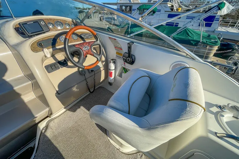 Slide: The Image of Interior view of 2000 Sea Ray 260 Sundancer boat cockpit with steering wheel and controls. - 10