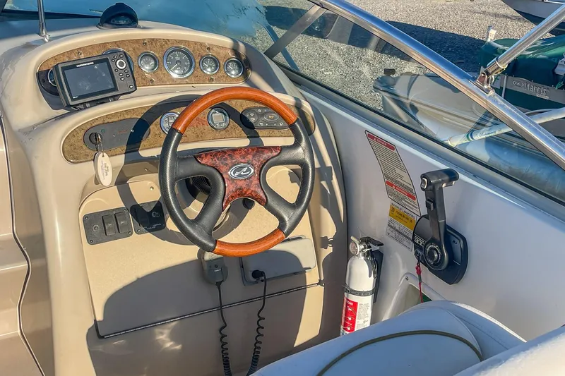Slide: The Image of Steering console of a 2000 Sea Ray 260 Sundancer boat with wood accents and navigation equipment. - 11