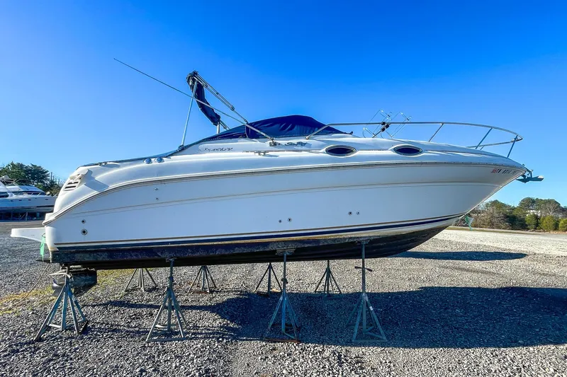 Slide: The Image of 2000 Sea Ray 260 Sundancer boat on stands under clear blue sky. - 2