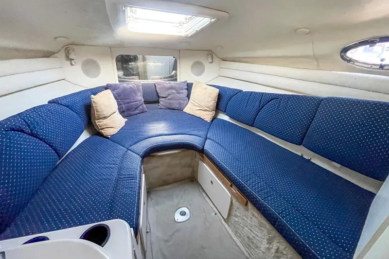 Slide: The Image of Interior of 2000 Sea Ray 260 Sundancer with blue cushioned seating and pillows. - 20