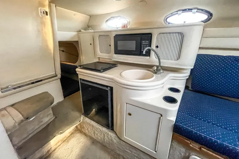 Slide: The Image of Interior of 2000 Sea Ray 260 Sundancer with kitchenette, sink, and seating area. - 22