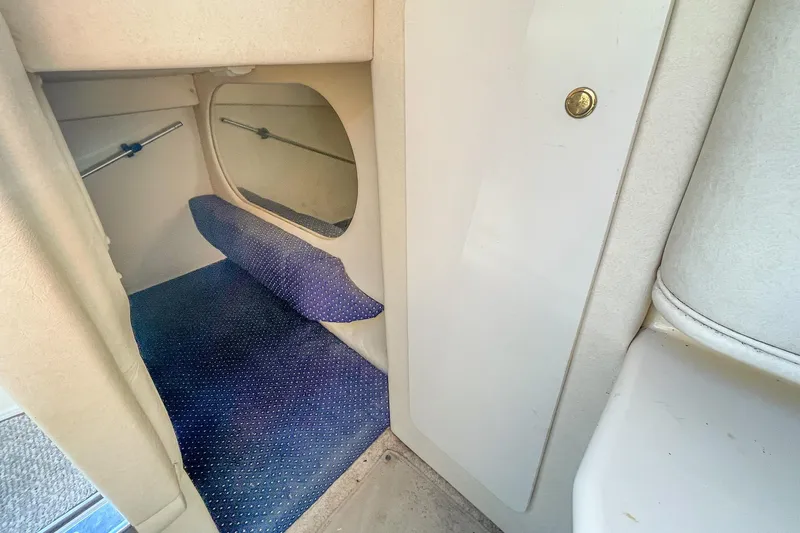Slide: The Image of Interior cabin of 2000 Sea Ray 260 Sundancer with blue carpet and storage space. - 25