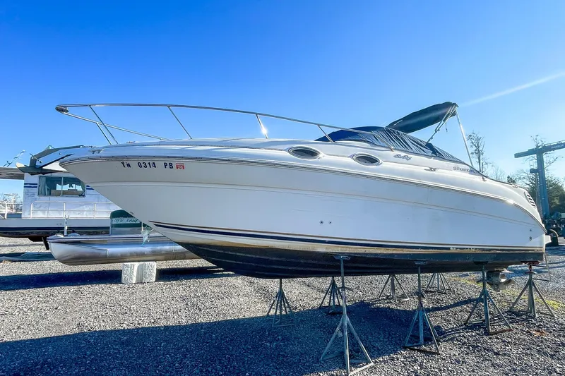 Slide: The Image of 2000 Sea Ray 260 Sundancer boat on stands under clear blue sky. - 4