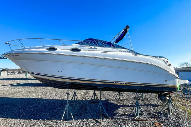 Slide: The Image of 2000 Sea Ray 260 Sundancer boat on stands under clear blue sky. - 5