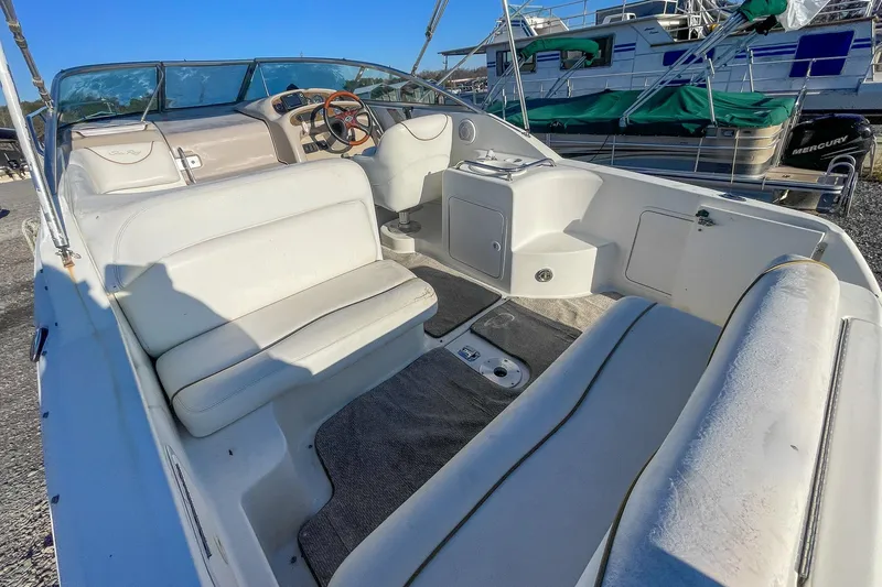 Slide: The Image of 2000 Sea Ray 260 Sundancer boat interior with white seating and steering wheel. - 8