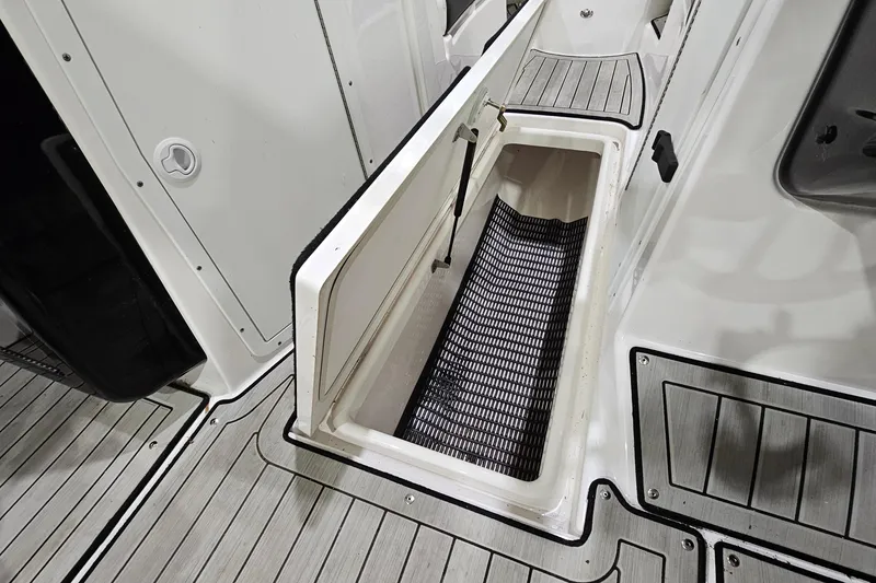 Slide: The Image of 2024 Yamaha Boats 222SE storage compartment with open hatch and non-slip flooring. - 22
