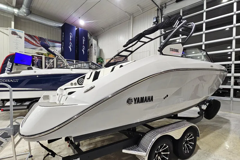 Slide: The Image of 2024 Yamaha Boats 222SE displayed in a showroom, sleek white design on a trailer. - 3