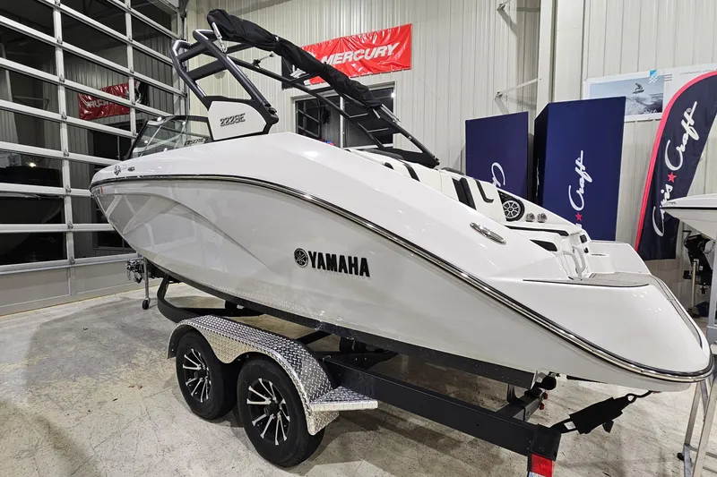 Slide: The Image of 2024 Yamaha Boats 222SE in showroom, sleek white design on trailer. - 4
