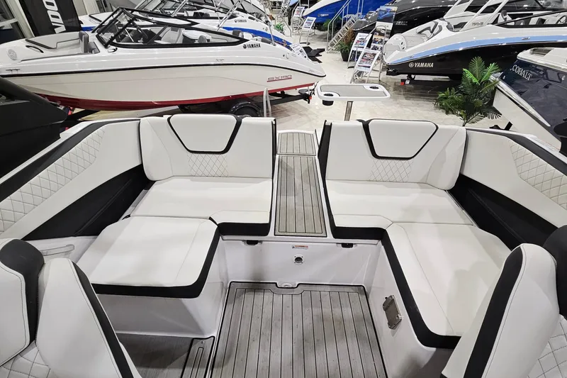 Slide: The Image of 2024 Yamaha Boats 222SE interior with white seating and sleek design at a boat show. - 9