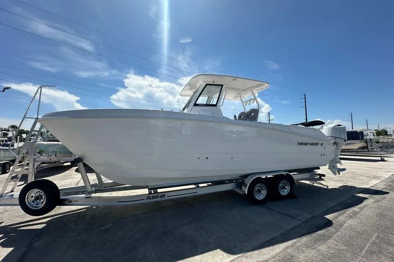 The Image of 2025 Twin Vee 260 GFX2 CC boat on trailer under clear sky. - 1