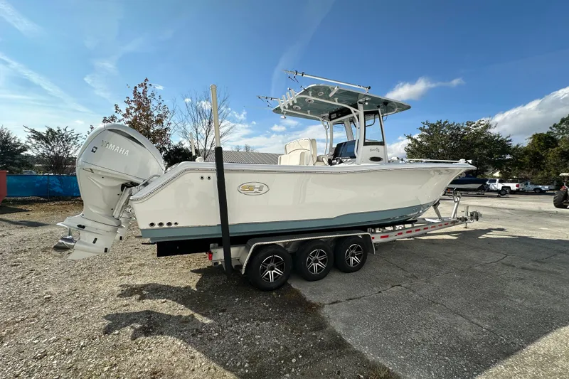 Slide: The Image of 2022 Sea Hunt Gamefish 30 Coffin Box boat on trailer, featuring Yamaha engines. - 8
