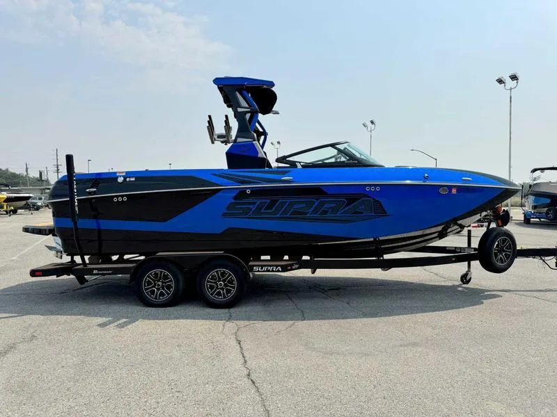 Slide: The Image of 2019 Supra SL450 boat in blue and black on a trailer in a parking lot. - 5