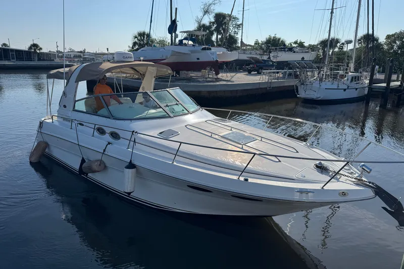 The Image of 2002 Sea Ray 310 Sundancer yacht docked in a marina, sunny day. - 0