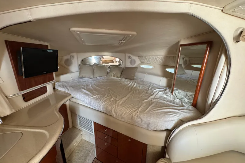 Slide: The Image of Interior cabin of 2002 Sea Ray 310 Sundancer with bed, TV, and storage. - 12