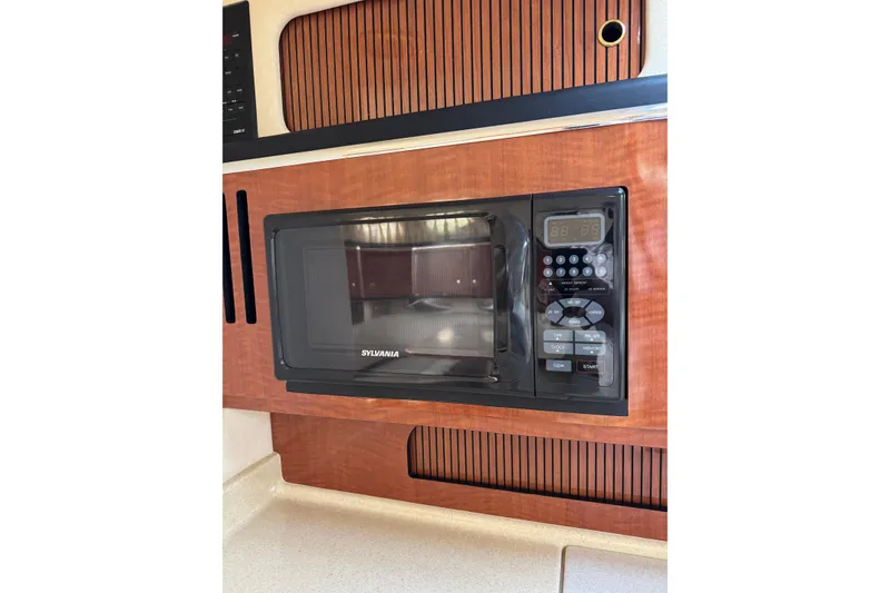 Slide: The Image of Microwave in 2002 Sea Ray 310 Sundancer yacht kitchen, featuring wood paneling. - 17