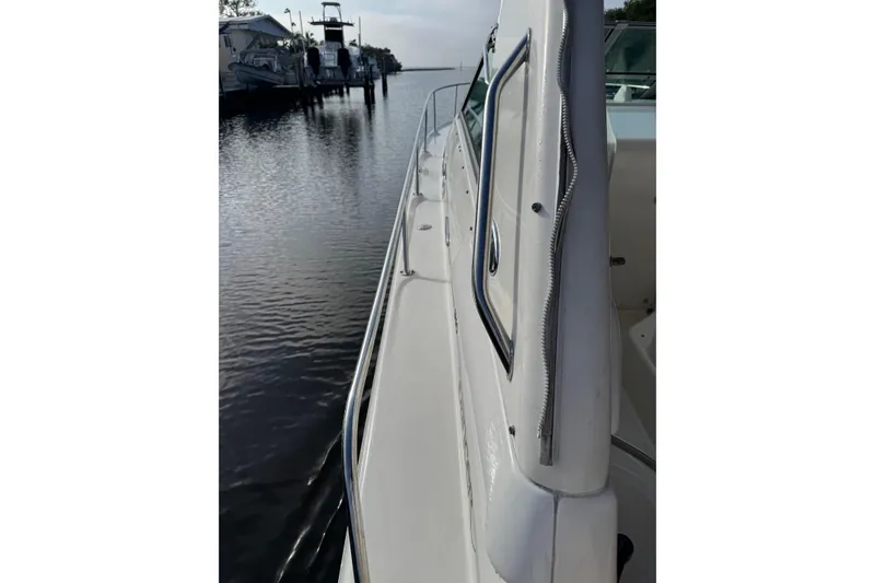 Slide: The Image of 2002 Sea Ray 310 Sundancer yacht docked by calm waters. - 20