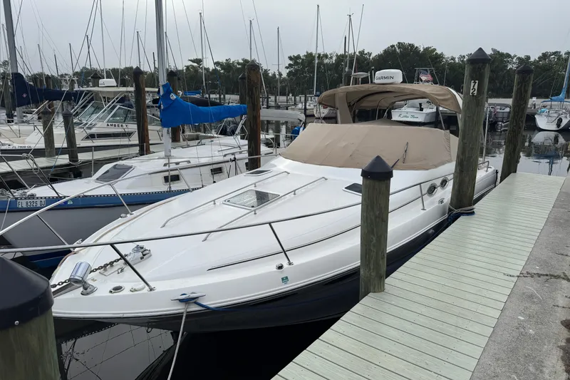 Slide: The Image of 2002 Sea Ray 310 Sundancer docked at a marina, surrounded by other boats. - 28