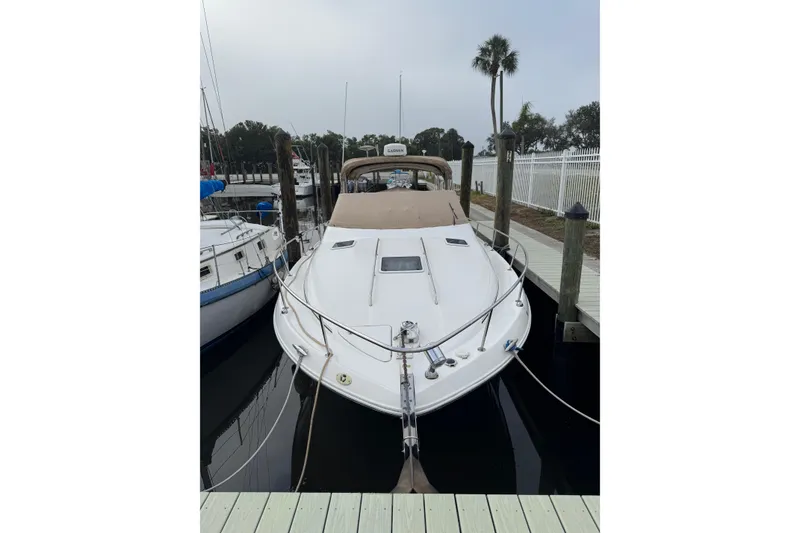 Slide: The Image of 2002 Sea Ray 310 Sundancer docked at marina, front view with calm water. - 29