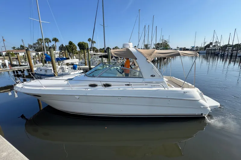 Slide: The Image of 2002 Sea Ray 310 Sundancer boat docked in a marina under clear blue skies. - 3