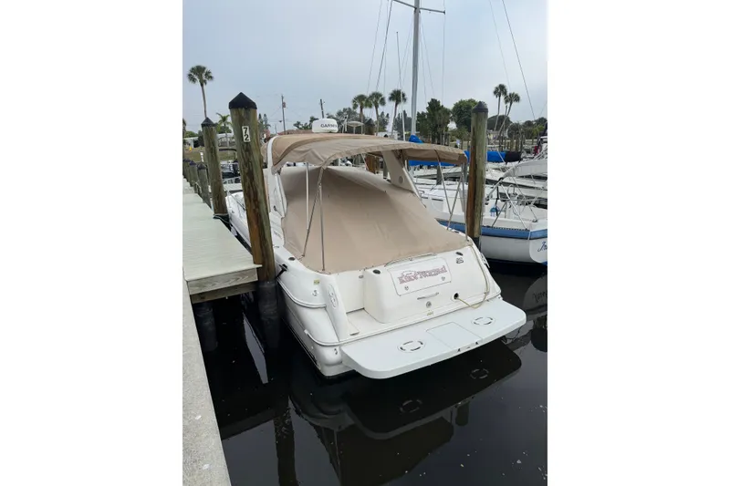 Slide: The Image of 2002 Sea Ray 310 Sundancer docked at marina with beige cover. - 30