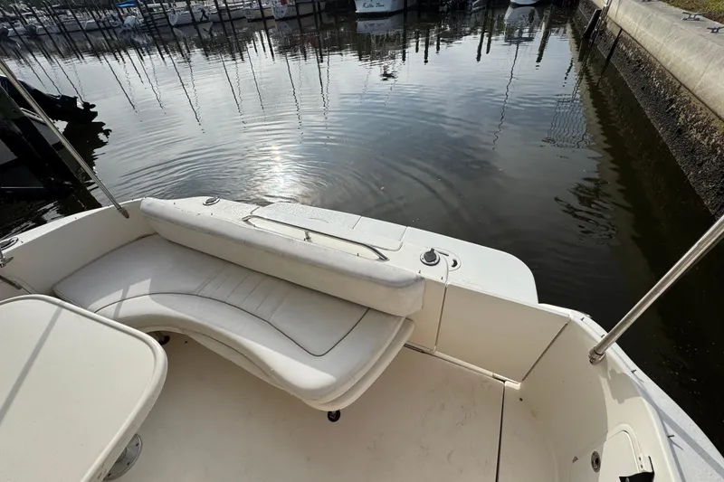 Slide: The Image of 2002 Sea Ray 310 Sundancer boat interior with white seating, docked in marina. - 4