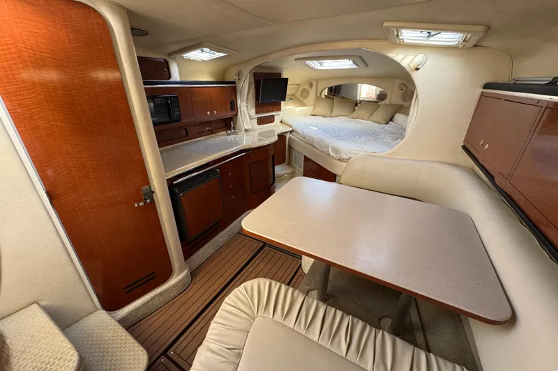Slide: The Image of Interior of 2002 Sea Ray 310 Sundancer yacht with kitchen, dining area, and bed. - 9