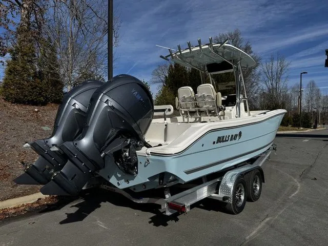 Slide: The Image of 2025 Bulls Bay 255CC boat on trailer with dual outboard engines, parked outdoors. - 3