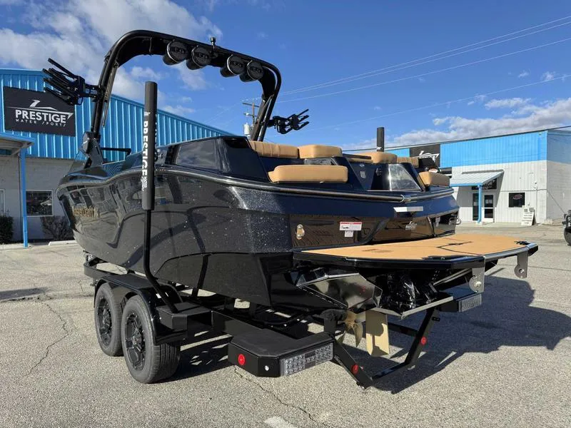 Slide: The Image of 2025 MasterCraft XT24 boat on trailer, black exterior, parked outside dealership. - 5