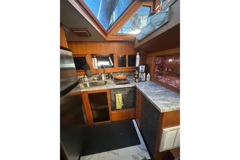 Slide: The Image of 1986 Lien Hwa 42 yacht kitchen with skylight, modern appliances, and wooden cabinetry. - 17