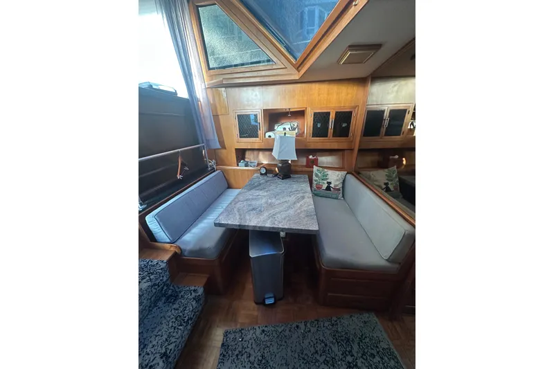 Slide: The Image of 1986 Lien Hwa 42 yacht interior with cozy dining area and wooden cabinetry. - 6