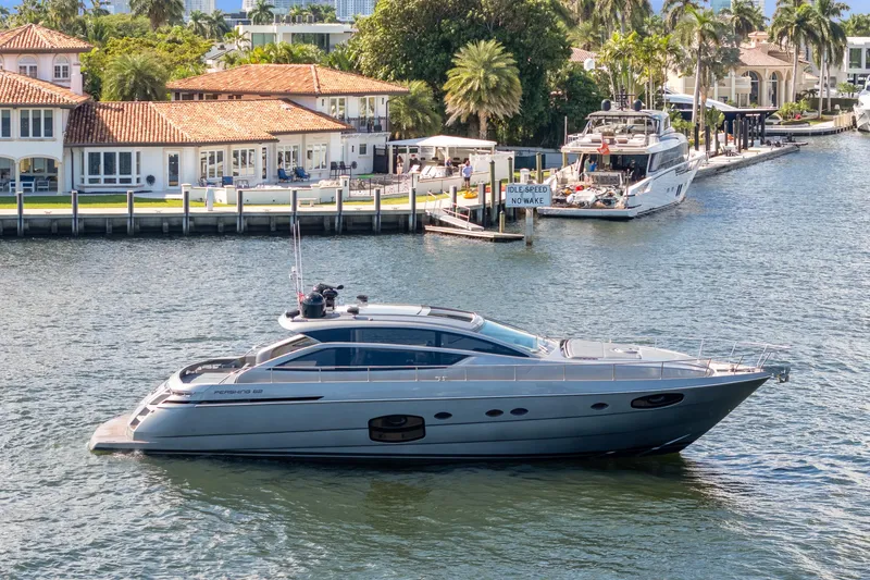The Image of 2016 Pershing 62' yacht cruising near waterfront homes and docks. - 0