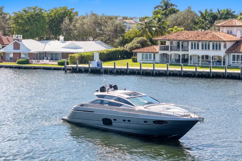 Slide: The Image of Luxury 2016 Pershing 62' yacht cruising near waterfront homes. - 1