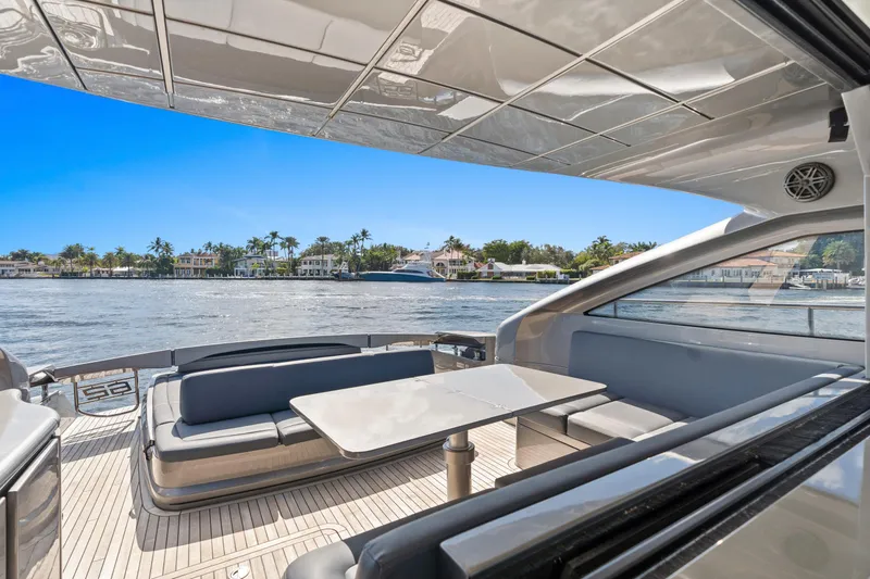 Slide: The Image of Luxurious 2016 Pershing 62' yacht with elegant seating and scenic waterfront view. - 10