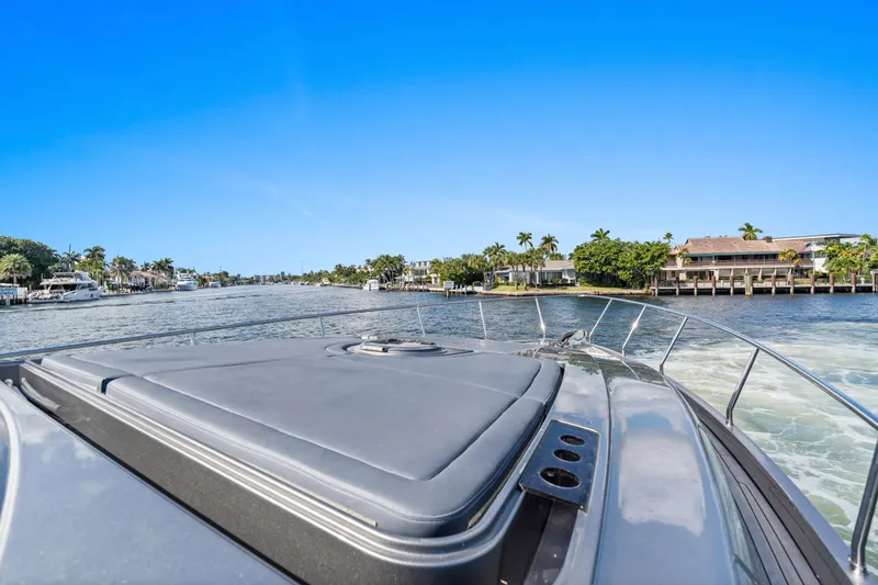 Slide: The Image of 2016 Pershing 62' yacht cruising on a scenic waterway with waterfront homes. - 12